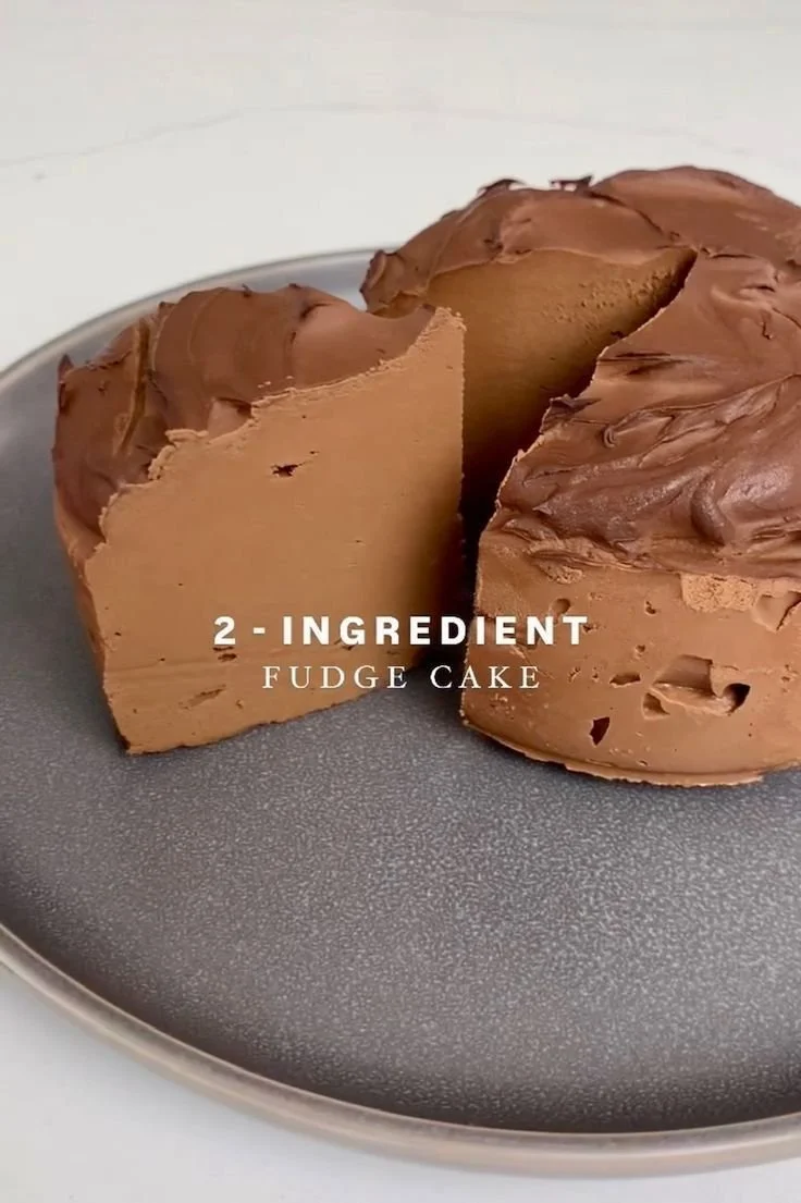 Delicious 2-ingredient fudge cake served on a plate with a chocolate glaze.
