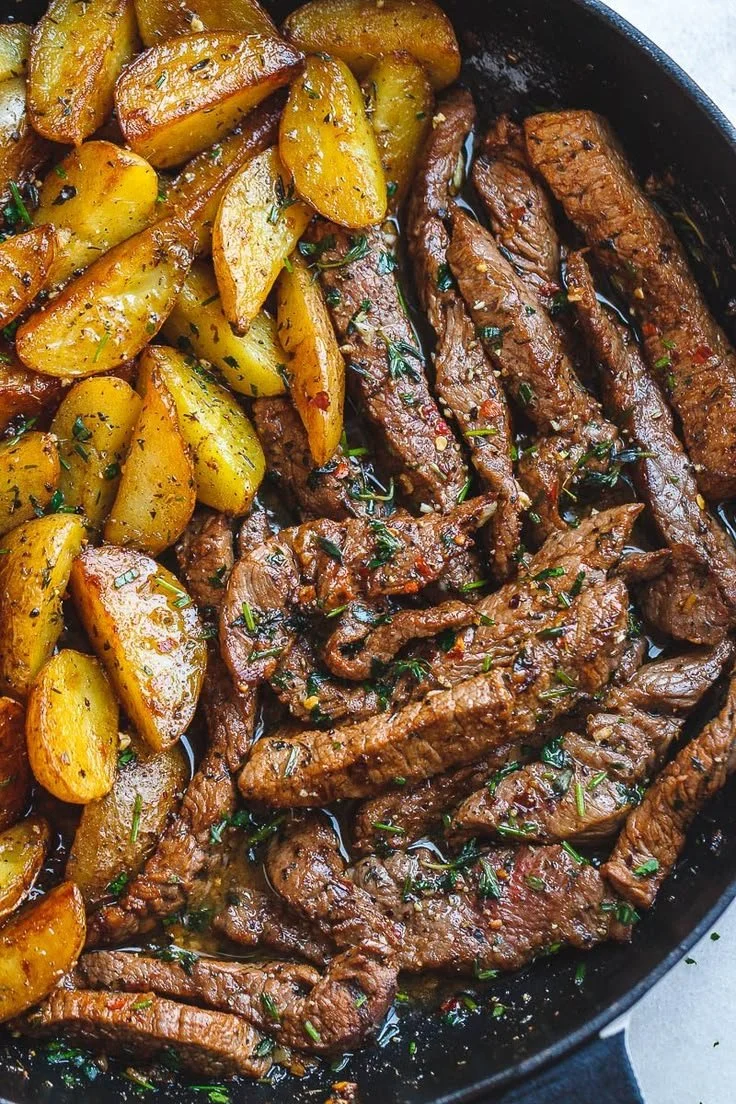 Skillet steak with garlic butter and potatoes served on a plate