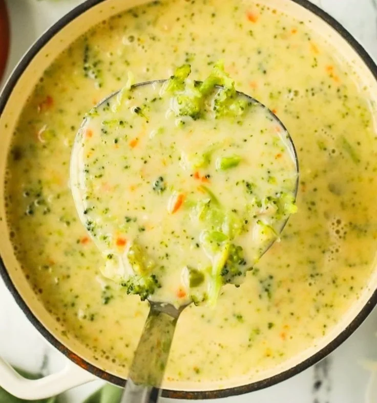 Bowl of creamy broccoli cheddar soup garnished with fresh broccoli florets