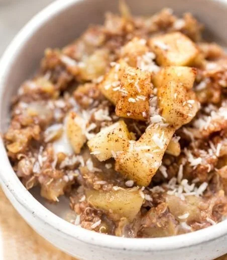Bowl of Cinnamon Apple Breakfast Quinoa topped with fresh apples and cinnamon.