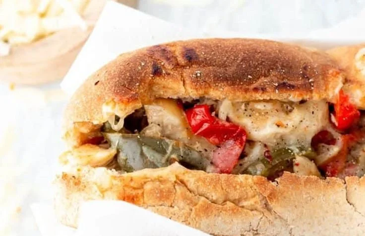Delicious crockpot chicken Philly cheesesteak served with peppers and onions