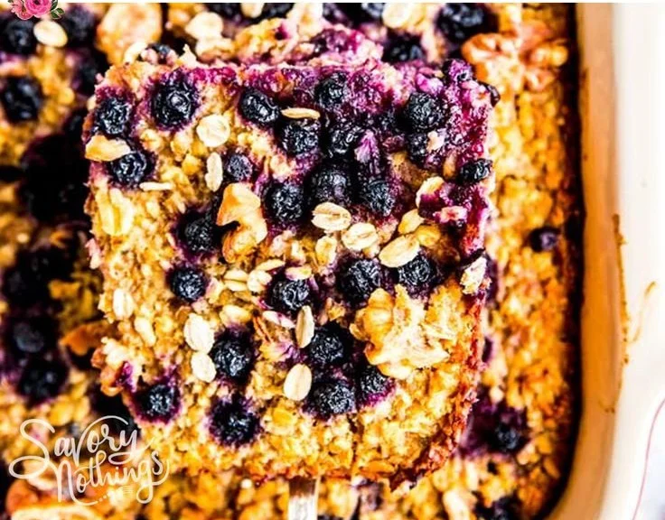 Delicious blueberry baked oatmeal in a baking dish topped with fresh blueberries.