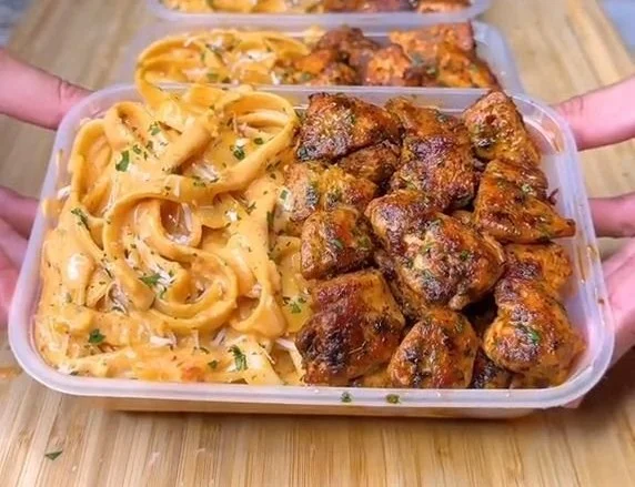 High protein grilled chicken alfredo pasta dish garnished with parsley