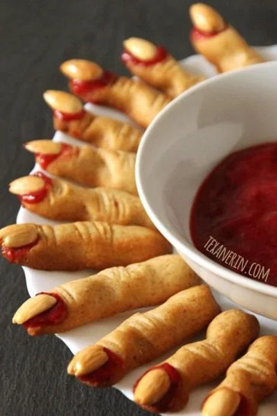 Colorful and spooky Halloween appetizers displayed on a haunted-themed table.