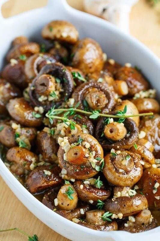 Roasted mushrooms in browned butter, garlic, and thyme sauce on a plate